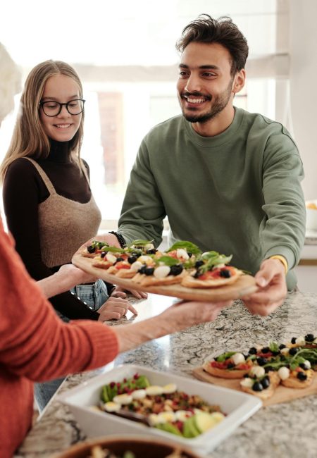 man offering plate of food, representing Fort Collins Nutrition's Services